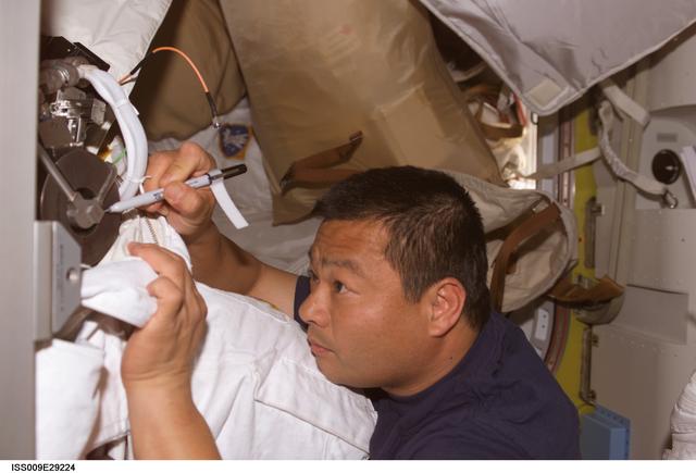 NASA image: Chiao marks location on the EMU 3005 Fan/Pump/Separator Motor Assembly during Expedition 9/10 joint OPS