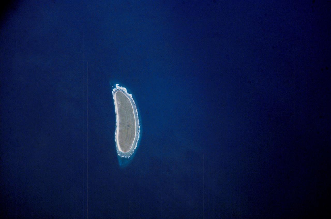 ISS010-E-09287 (3 December 2004) --- Howland Island, Oceania is featured in this digital image photographed by an Expedition 10 crewmember on the International Space Station (ISS). Howland Island is a United States possession located in the north Pacific between Australia and the Hawaiian Islands. Prior to 1890, organic nitrate (guano) was mined from the island by both the United States and the British. This tiny island is currently part of the US National Wildlife Refuge system, and provides nesting areas and forage for a variety of birds and marine wildlife. The island is composed of coral fragments and is surrounded by an active fringing reef. White breakers encircling the island indicate the position of the reef. Astronauts aboard the Space Station photograph numerous reefs around the world as part of a global mapping and monitoring program. High-resolution images such as this one are used to update geographic maps of reefs and islands, assess the health of reef ecosystems, and calculate bathymetry of the surrounding ocean bottom.