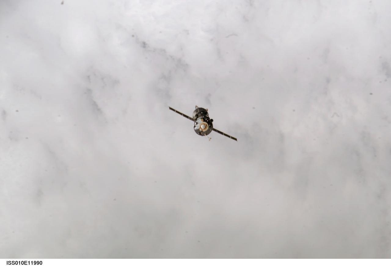 ISS010-E-11990 (22 December 2004) --- Backdropped by a blanket of clouds, an unpiloted Progress 15 supply vehicle departs from the International Space Station (ISS) at 1:37 pm (CST) on December 22, 2004, carrying its load of trash and unneeded equipment to be deorbited and burned up in Earths atmosphere. The undocking clears the way for the arrival of a new Progress 16, planned to launch December 23 and dock with the Station on December 25.