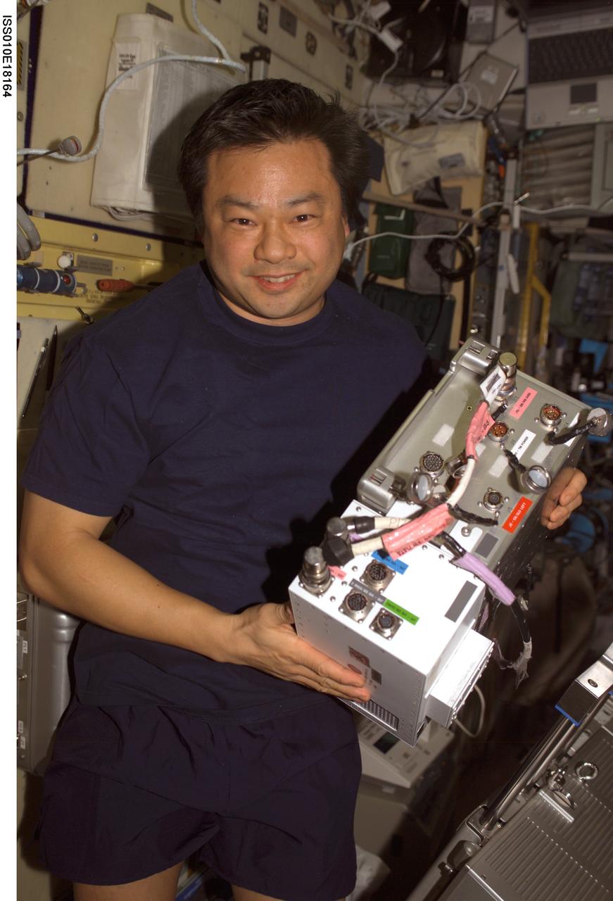 ISS010-E-18164 (17 February 2005) --- Astronaut Leroy Chiao, Expedition 10 commander and NASA ISS science officer, holds an Electronic Box Assembly, and Violation Isolation and Stabilization (VIS) Controller Assembly, which is part of the Treadmill Vibration Isolation System (TVIS) in the Zvezda Service Module of the International Space Station (ISS). Also in view is a VIS/TM data cable and VIS/TM power cable. This box receives power and distributes it between the treadmill and the VIS subassemblies.