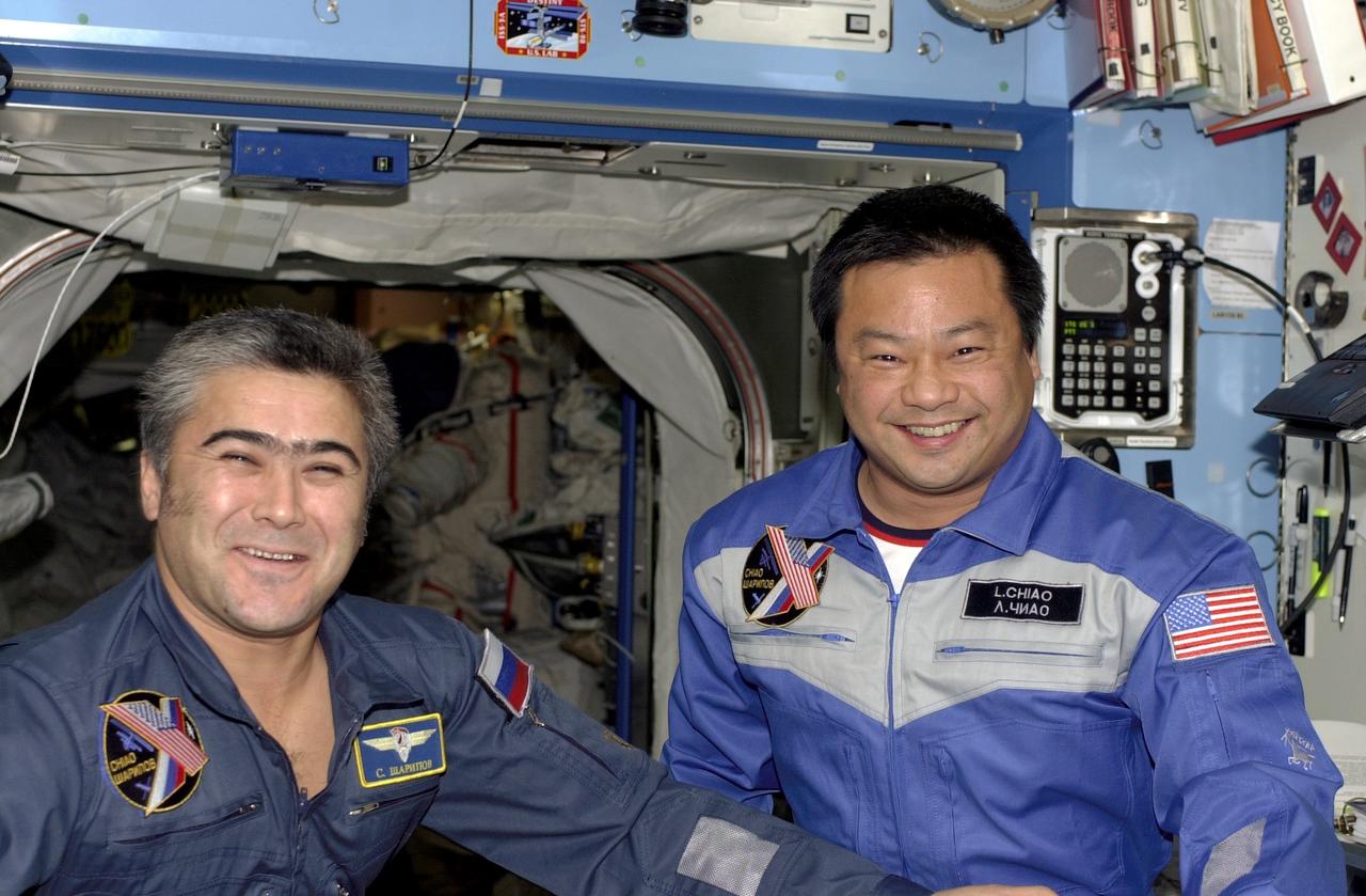 ISS010-E-18943 (23 November 2004) --- Cosmonaut Salizhan S. Sharipov (left), Expedition 10 flight engineer, and astronaut Leroy Chiao,  commander and NASA Space Station science officer, appear to be enjoying their work in the early stages of their tenure aboard the orbiting complex. They stand near the hatchway for the Destiny Laboratory.