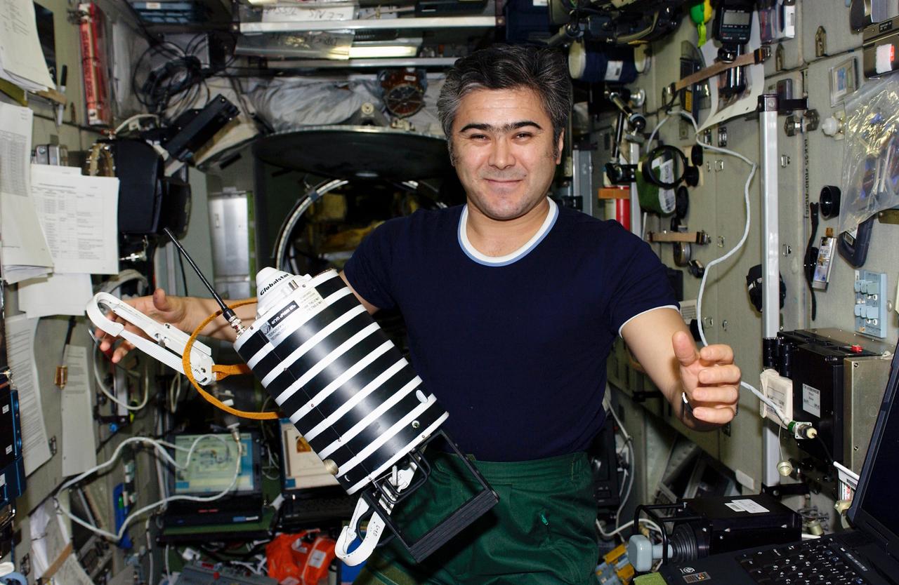 ISS010-E-20722 (21 March 2005) --- Cosmonaut Salizhan S. Sharipov, Expedition 10 flight engineer representing Russia's Federal Space Agency, holds “Nanosputnik” (TEKh-42) in the Zvezda Service Module of the International Space Station (ISS). This small (5 kilogram mass) satellite, powered by 10 lithium thionyl chloride batteries, will be activated by Sharipov after his egress from the Pirs Docking Compartment and later “launched” into its own orbit during the spacewalk scheduled for March 28. The purpose of Nanosputnik is to support development of satellite control techniques, monitoring of satellite operations, and research on new attitude system sensors and other components.