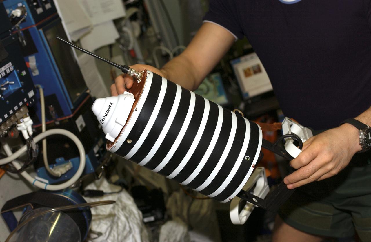ISS010-E-20726 (21 March 2005) --- This close-up view of &#0147;Nanosputnik&#0148; (TEKh-42), held by cosmonaut Salizhan S. Sharipov (partially out of frame), Expedition 10 flight engineer representing Russia's Federal Space Agency, was photographed in the Zvezda Service Module of the International Space Station (ISS). This small (5 kilogram mass) satellite, powered by 10 lithium thionyl chloride batteries, will be activated by Sharipov after his egress from the Pirs Docking Compartment and later &#0147;launched&#0148; into its own orbit during the spacewalk scheduled for March 28. The purpose of Nanosputnik is to support development of satellite control techniques, monitoring of satellite operations, and research on new attitude system sensors and other components.