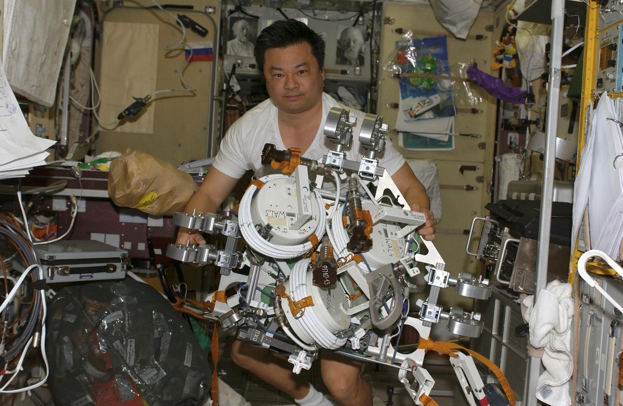 ISS010-E-20747 (21 March 2005) --- Astronaut Leroy Chiao, Expedition 10 commander and NASA ISS science officer, works with a tool caddy containing extravehicular activities (EVA) equipment and tools in the Zvezda Service Module of the International Space Station (ISS) in preparation for the spacewalk scheduled for March 28.