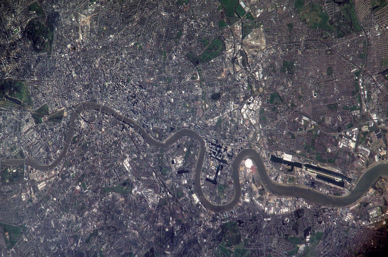ISS010-E-22495 (2 April 2005) --- Numerous recognizable features appear in this detailed view of London, United Kingdom, photographed by an Expedition 10 crewmember on the International Space Station (ISS). The photographer had to look back along track for the shot, from a position over northern Germany. The most striking visual features are green open spaces such as Regent’s Park, Hyde Park and St. James’s Park east of Buckingham Palace. Many smaller parks indicate why Londoners are proud of being able to walk miles through the city mainly on grass. The River Thames—with its bridges and barges (some of the more than 14,000 craft registered to sail the Thames)—is the axis upon which the city was founded in Roman times. The relatively small area known as the City of London coincides with the ancient walled Roman city of Londinium on the north bank of the river (the line of the wall is marked closely for almost its entire length by modern streets), and includes St. Paul’s Cathedral near where the Roman temple stood. For scale, the river is 265 meters wide near St. Paul’s. The City is the financial center while Westminster is the center of government, including the Houses of Parliament and Downing Street, where the British Prime Minister lives. Several large structures visible in this image are railroad stations; three serving areas north of London (Euston, St. Pancras and King’s Cross), and Waterloo Station serving southern Britain. The London Eye, a famous Ferris wheel 140 meters high, is situated on an oval island in the River Thames, visible just west of Waterloo Station. Many larger buildings can also be identified, partly because they cast shadows—Buckingham Palace, St Paul’s Cathedral, and the Tate Modern art museum (a converted power station, the 99-meter chimney was designed to fall just short of the crest of St Paul’s dome).