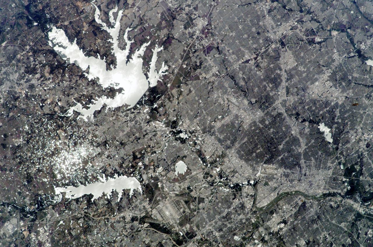 ISS010-E-24596 (14 April 2005) --- Dallas, Texas is featured in this image photographed by an Expedition 10 crew member on the International Space Station. The Dallas-Fort Worth metropolitan area is the largest in Texas with an approximate population of 6 million people in 2005. Founded by John Neely Bryan in 1841, the city became the center for the United States oil economy with the discovery of oilfields to the east of the city in 1930. The Dallas-Forth Worth region today is a major corporate, banking, and technological center. This image captures the northwestern portion of the metropolitan area. Standing water bodies such as Lake Lewisville and Grapevine Lake are highlighted by sunglint, where the surface of the water acts as a mirror reflecting sunlight back towards the astronauts on the Station. Using the sunglint to define edges of water helps when mapping water bodies and stream courses on a landscape ? note the region of small ponds to the north of Grapevine Lake highlighted by sunglint. Photo credit: NASA