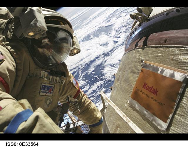 ISS010-E-33564 (26 January 2005) --- Astronaut Leroy Chiao, Expedition 10 commander and NASA ISS science officer, wearing a Russian Orlan spacesuit, participates in the first of two sessions of extravehicular activities (EVA) performed by the Expedition 10 crew during their six-month mission. Chiao and cosmonaut Salizhan S. Sharipov (out of frame), flight engineer representing Russia's Federal Space Agency, spent 5 ½ hours outside the International Space Station (ISS) installing a work platform, cables and robotic and scientific experiments on the exterior of the Zvezda Service Module. A cloudy Earth provided the backdrop for the image.