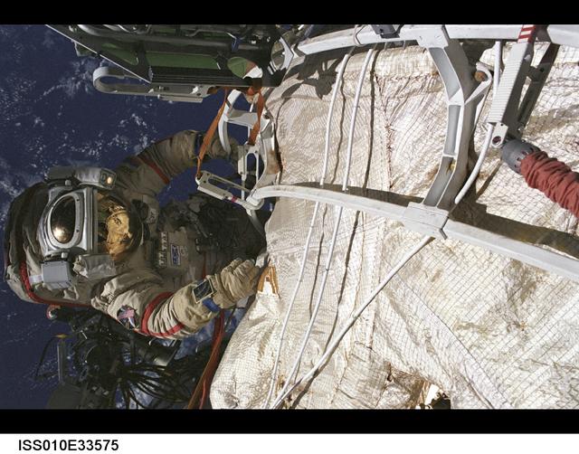 ISS010-33575 (28 March 2005) --- Cosmonaut Salizhan S. Sharipov, Expedition 10 flight engineer representing Russia's Federal Space Agency, wearing a Russian Orlan spacesuit, participates in the second of two sessions of extravehicular activities (EVA) performed by the Expedition 10 crew during their six-month mission. Sharipov and astronaut Leroy Chiao (out of frame), commander and NASA ISS science officer, spent 4 ½ hours outside the International Space Station (ISS) installing navigational and communications equipment for the arrival of the first Automated Transfer Vehicle cargo craft. Sharipov also deployed an 11-pound Russian nanosatellite.