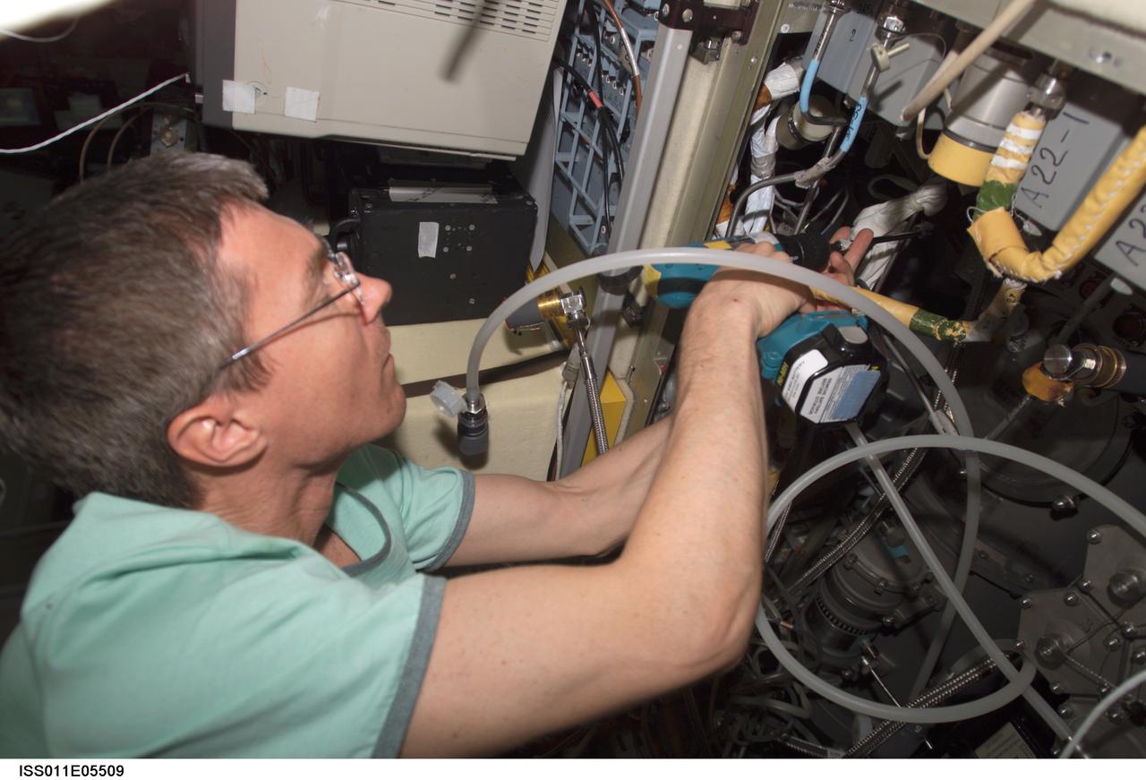 ISS011-E-05509 (5 May 2005) --- Cosmonaut Sergei K. Krikalev, Expedition 11 commander representing Russia's Federal Space Agency, uses a power tool as he makes repairs to the Elektron oxygen generator in the Zvezda Service Module of the International Space Station (ISS).