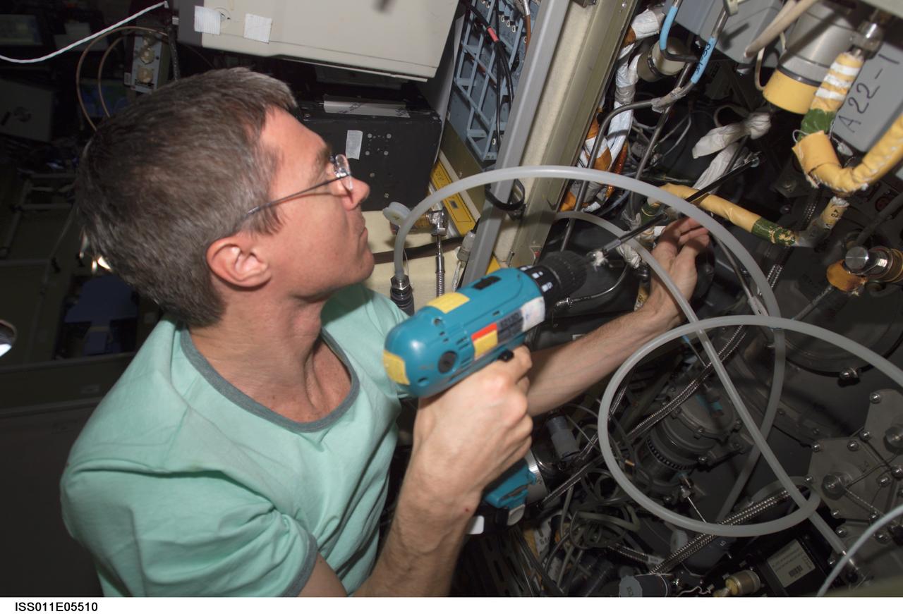 ISS011-E-05510 (5 May 2005) --- Cosmonaut Sergei K. Krikalev, Expedition 11 commander representing Russia's Federal Space Agency, uses a power tool as he makes repairs to the Elektron oxygen generator in the Zvezda Service Module of the International Space Station (ISS).
