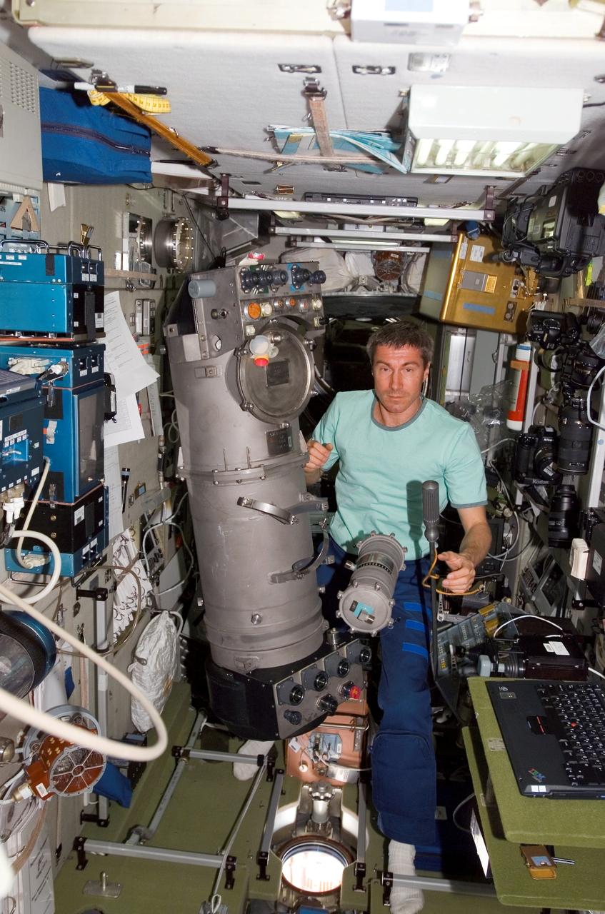 ISS011-E-05513 (5 May 2005) --- Cosmonaut Sergei K. Krikalev, Expedition 11 commander representing Russia's Federal Space Agency, poses beside the disconnected Liquid Unit #5 (BZh-5) and the O2 end-filter (BD, secondary purification unit) from the BZh5 he removed while making repairs to the Elektron oxygen generator in the Zvezda Service Module of the international space station.