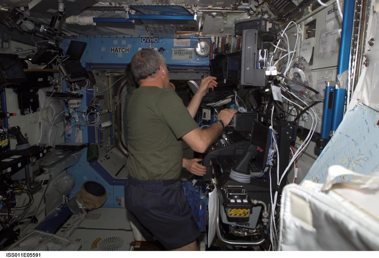 ISS011-E-05591 (6 May 2005) --- Astronaut John L. Phillips, Expedition 11 NASA ISS science officer, and cosmonaut Sergei K. Krikalev (obscured), commander representing Russia's Federal Space Agency, participate in a proficiency training session with the Canadarm2, or Space Station Remote Manipulator System (SSRMS) in the Destiny laboratory of the International Space Station (ISS).