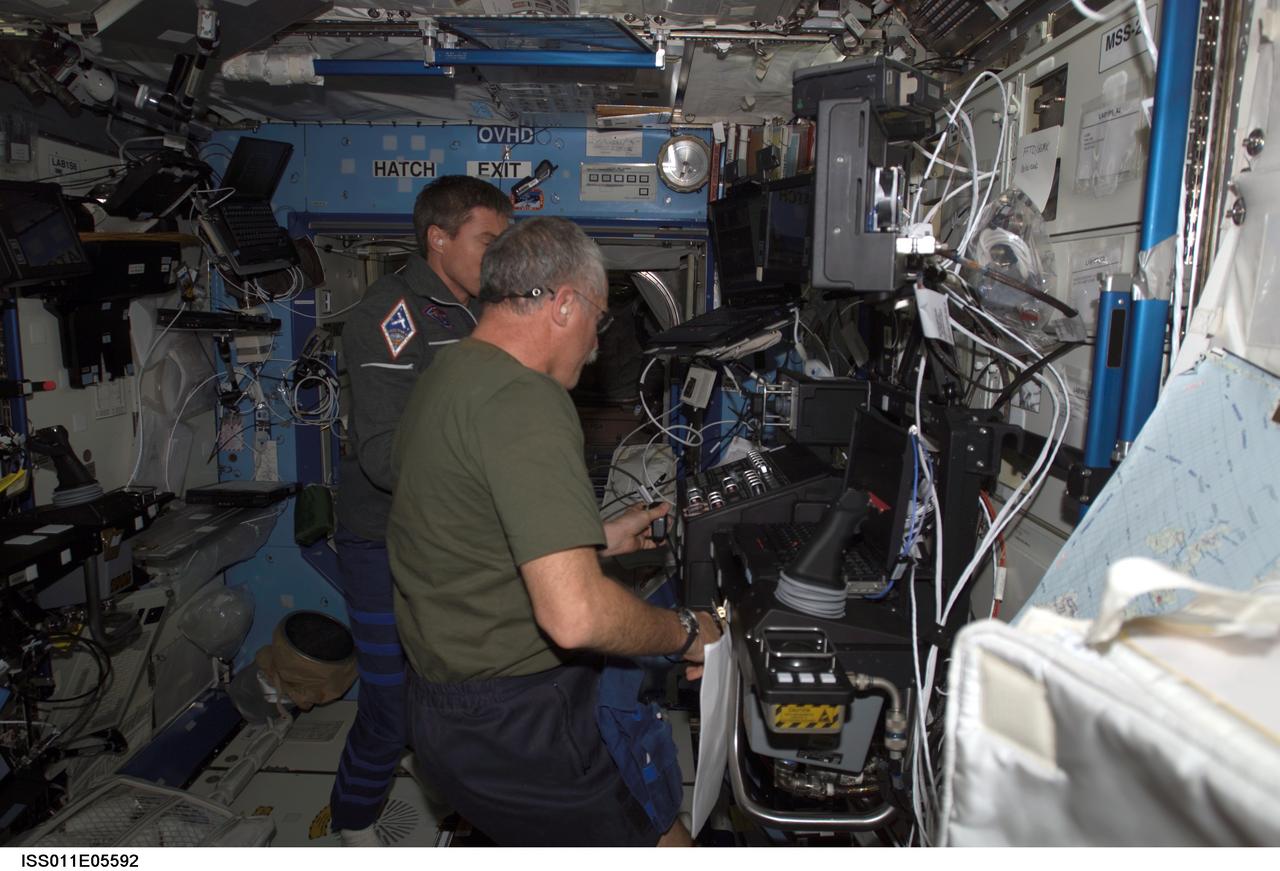 ISS011-E-05592 (6 May 2005) --- Astronaut John L. Phillips, Expedition 11 NASA ISS science officer, and cosmonaut Sergei K. Krikalev (obscured), commander representing Russia's Federal Space Agency, participate in a proficiency training session with the Canadarm2, or Space Station Remote Manipulator System (SSRMS) in the Destiny laboratory of the International Space Station (ISS).