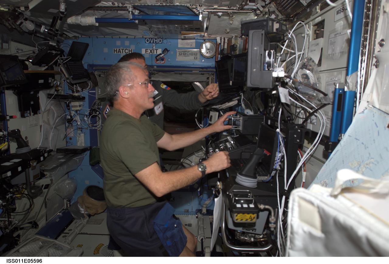 ISS011-E-05596 (6 May 2005) --- Astronaut John L. Phillips, Expedition 11 NASA ISS science officer, and cosmonaut Sergei K. Krikalev (obscured), commander representing Russia's Federal Space Agency, participate in a proficiency training session with the Canadarm2, or Space Station Remote Manipulator System (SSRMS) in the Destiny laboratory of the International Space Station (ISS).