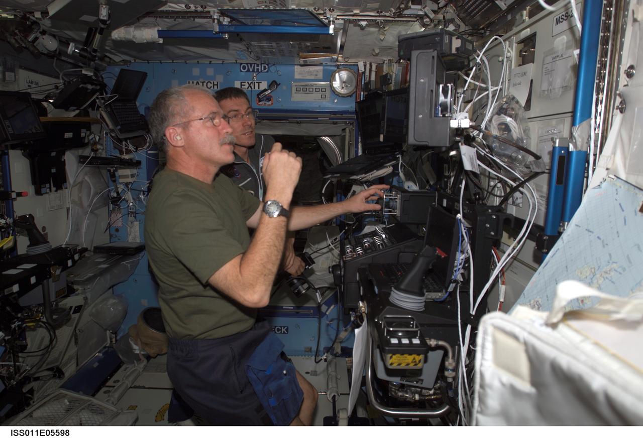 ISS011-E-05598 (6 May 2005) --- Astronaut John L. Phillips, Expedition 11 NASA ISS science officer, and cosmonaut Sergei K. Krikalev (partially obscured), commander representing Russia's Federal Space Agency, participate in a proficiency training session with the Canadarm2, or Space Station Remote Manipulator System (SSRMS) in the Destiny laboratory of the International Space Station (ISS).