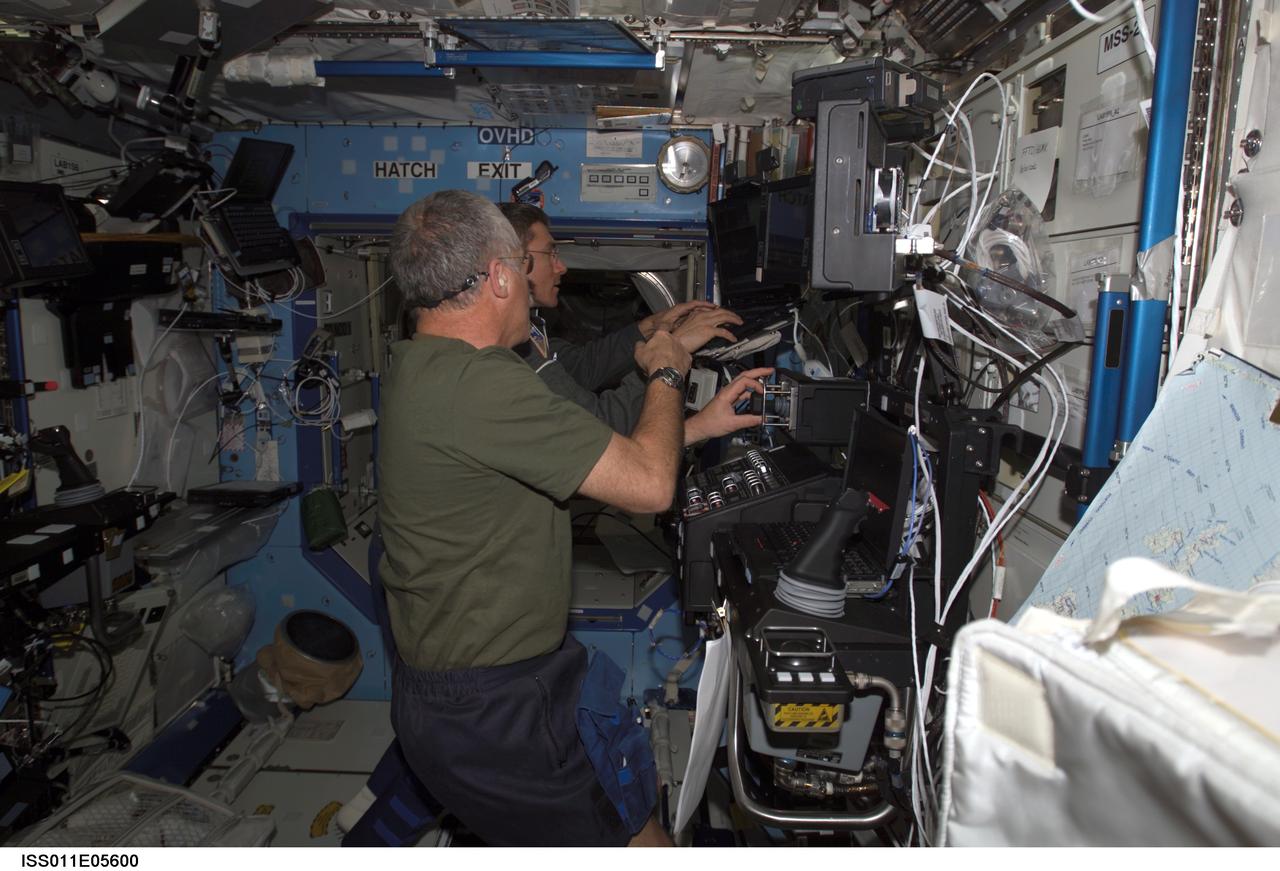 ISS011-E-05600 (6 May 2005) --- Astronaut John L. Phillips, Expedition 11 NASA ISS science officer, and cosmonaut Sergei K. Krikalev (obscured), commander representing Russia's Federal Space Agency, participate in a proficiency training session with the Canadarm2, or Space Station Remote Manipulator System (SSRMS) in the Destiny laboratory of the International Space Station (ISS).