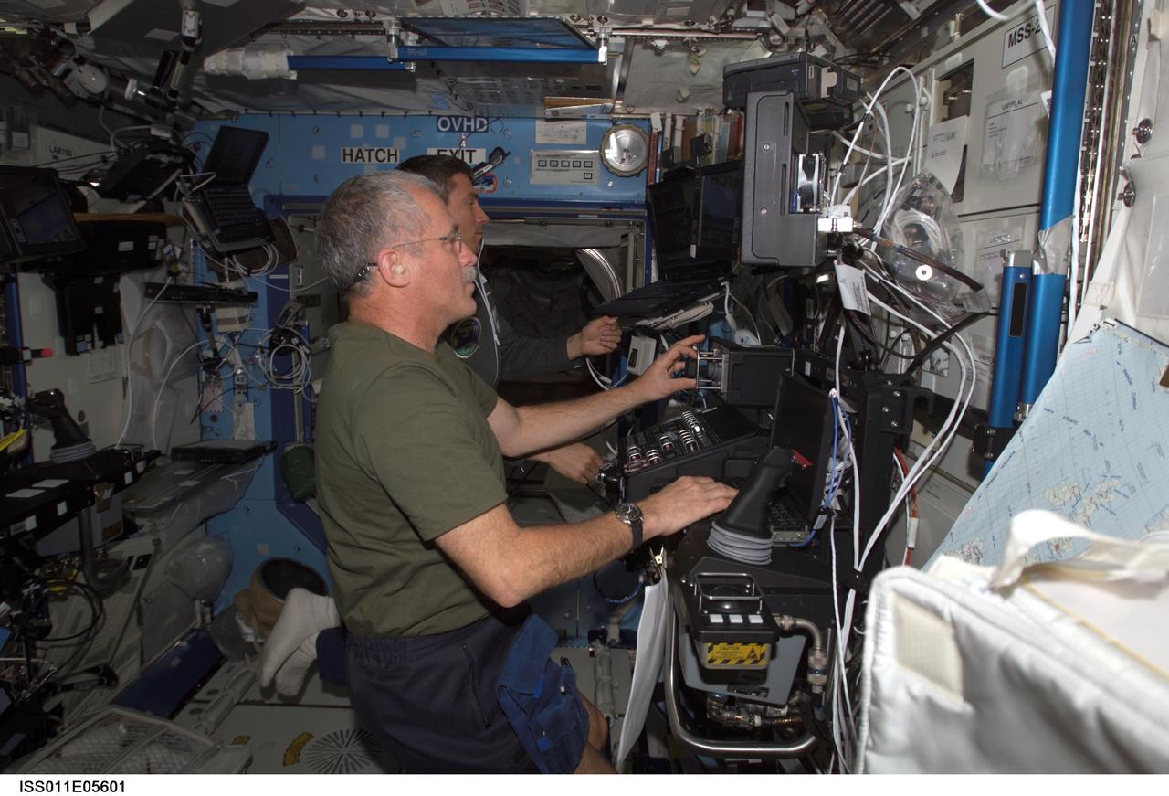 ISS011-E-05601 (6 May 2005) --- Astronaut John L. Phillips, Expedition 11 NASA ISS science officer, and cosmonaut Sergei K. Krikalev (partially obscured), commander representing Russia's Federal Space Agency, participate in a proficiency training session with the Canadarm2, or Space Station Remote Manipulator System (SSRMS) in the Destiny laboratory of the International Space Station (ISS).