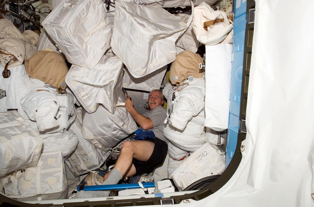 ISS011-E-06401 (18 May 2005) --- Astronaut John L. Phillips, Expedition 11 NASA science officer and flight engineer, is photographed among stowage bags in an airlock on the international space station.