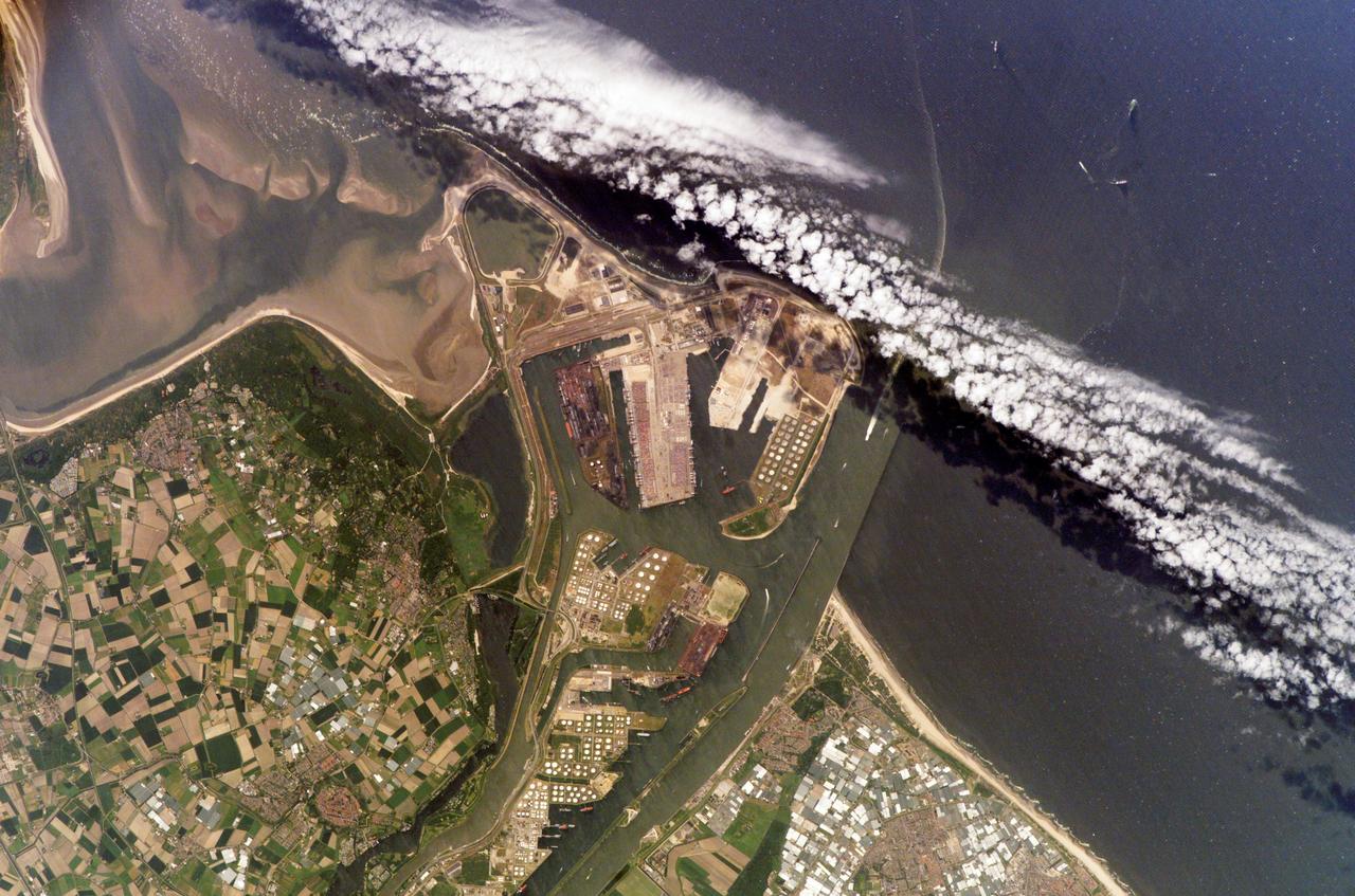 ISS011-E-07380 (28 May 2005) --- The Port of Rotterdam, Netherlands, is featured in this image photographed by an Expedition 11 crewmember on the International Space Station (ISS). The Port of Rotterdam, also known as Europoort (Eurogate), has been an important trading center since approximately 1250 A.D. This image illustrates the close proximity of the Europoort with the surrounding cities of Hoek van Holland, Oostvoorne, Brielle, and agricultural fields to the south. The presence of the port and its seawalls interrupts southward-flowing coastal currents, leading to accumulation of sediment to the south (upper left of image). Numerous ship wakes are visible within the port complex itself and in the upper right of the image.