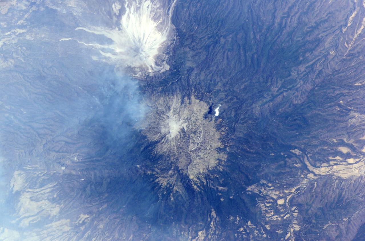 ISS011-E--8489 (10 June 2005) --- This digital still photograph, taken on June 10 from the Earth-orbiting International Space Station, shows an active Colima, the most prominent volcanic center of the western Mexican Belt.  Around 11 p.m. local time, June 6, an explosion from this volcano, for which the summit elevation is approximately 3,850 meters,  produced an ash plume to a height of approximately 8.5 kilometers (27,900 feet). The ash plume traveled southwest at a speed of approximately 79 kilometers per hour, and ash fell in and around the cities of Colima, about 30 kilometers away, and Villa de Alvarez.  Brief evacuation of some 50 residents in the area was considered a minor undertaking and it was reported some three days after this picture was taken that all were able to return to their homes.