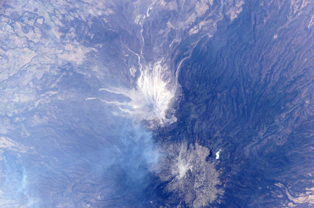 ISS011-E--8490 (10 June 2005) --- This digital still photograph, taken on June 10 from the Earth-orbiting International Space Station, shows an active Colima, the most prominent volcanic center of the western Mexican Belt.  Around 11 p.m. local time, June 6, an explosion from this volcano, for which the summit elevation is approximately 3,850 meters,  produced an ash plume to a height of approximately 8.5 kilometers (27,900 feet). The ash plume traveled southwest at a speed of approximately 79 kilometers per hour, and ash fell in and around the cities of Colima, about 30 kilometers away, and Villa de Alvarez.  Brief evacuation of some 50 residents in the area was considered a minor undertaking and it was reported some three days after this picture was taken that all were able to return to their homes.