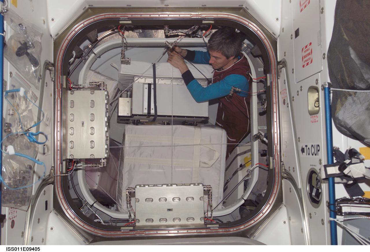 ISS011-E-09405 (21 June 2005) --- Cosmonaut Sergei K. Krikalev, Expedition 11 commander representing Russia's Federal Space Agency, moves stowage items from the Unity node into the Pressurized Mating Adapter (PMA-3) of the International Space Station (ISS).
