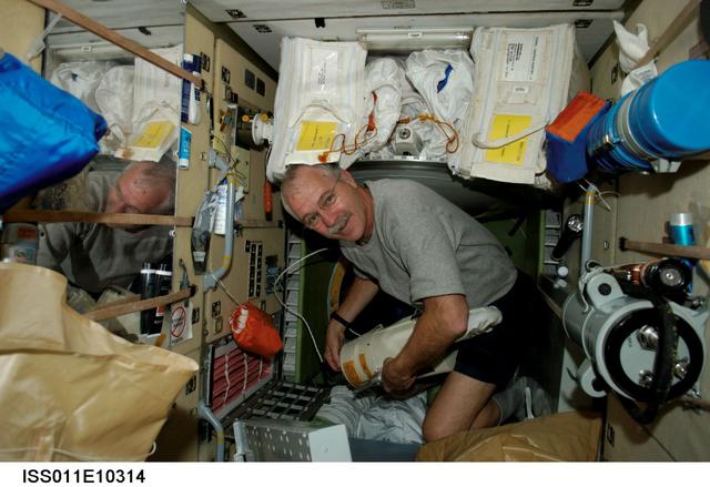 ISS011-E-10314 (4 May 2005) --- Astronaut John L. Phillips, Expedition 11 NASA Space Station science officer and flight engineer, assembles a vacuum cleaner in the functional cargo block (FGB) or Zarya on the International Space Station.