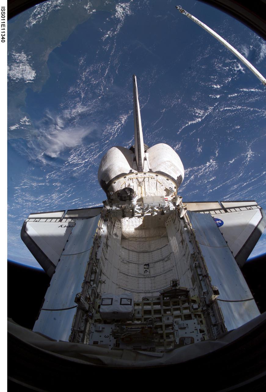 ISS011-E-11340 (29 July 2005) --- A "fish-eye" lens on a digital still camera was used to record this image of the Space Shuttle Discovery from the International Space Station, to which it is docked for several days of joint activities.