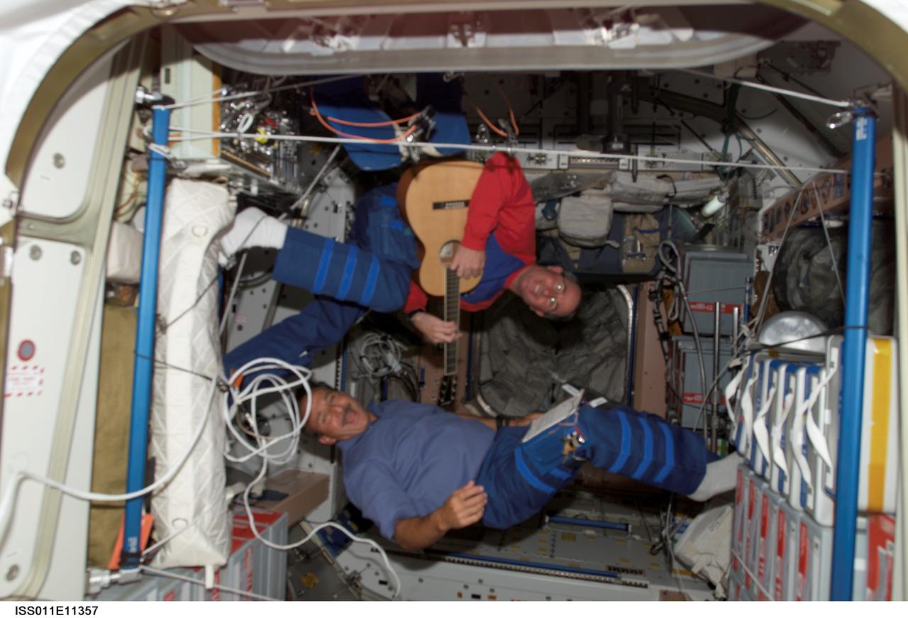 ISS011-E-11357 (30 July 2005) --- Astronauts Stephen K. Robinson and Charles J. Camarda, STS-114 mission specialists, share a light moment while Robinson plays a guitar in the Unity node of the International Space Station.