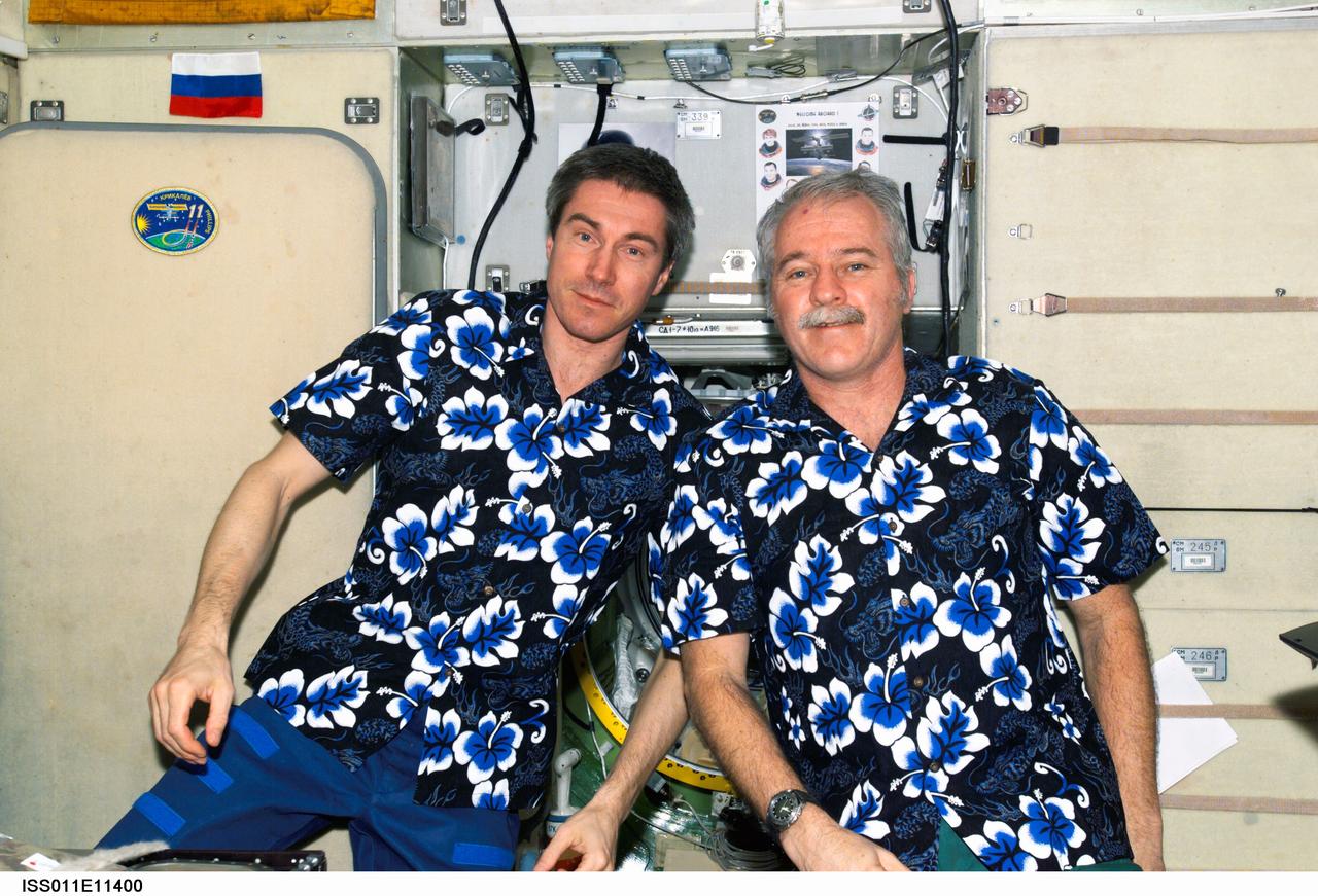 ISS011-E-11400 (31 July 2005) --- Cosmonaut Sergei K. Krikalev (left), Expedition 11 commander representing Russia's Federal Space Agency, and astronaut John L. Phillips, NASA Space Station science officer and flight engineer, pose for a photo in the Zvezda Service Module of the International Space Station. At the time, the two were playing host to the seven Discovery crewmembers.