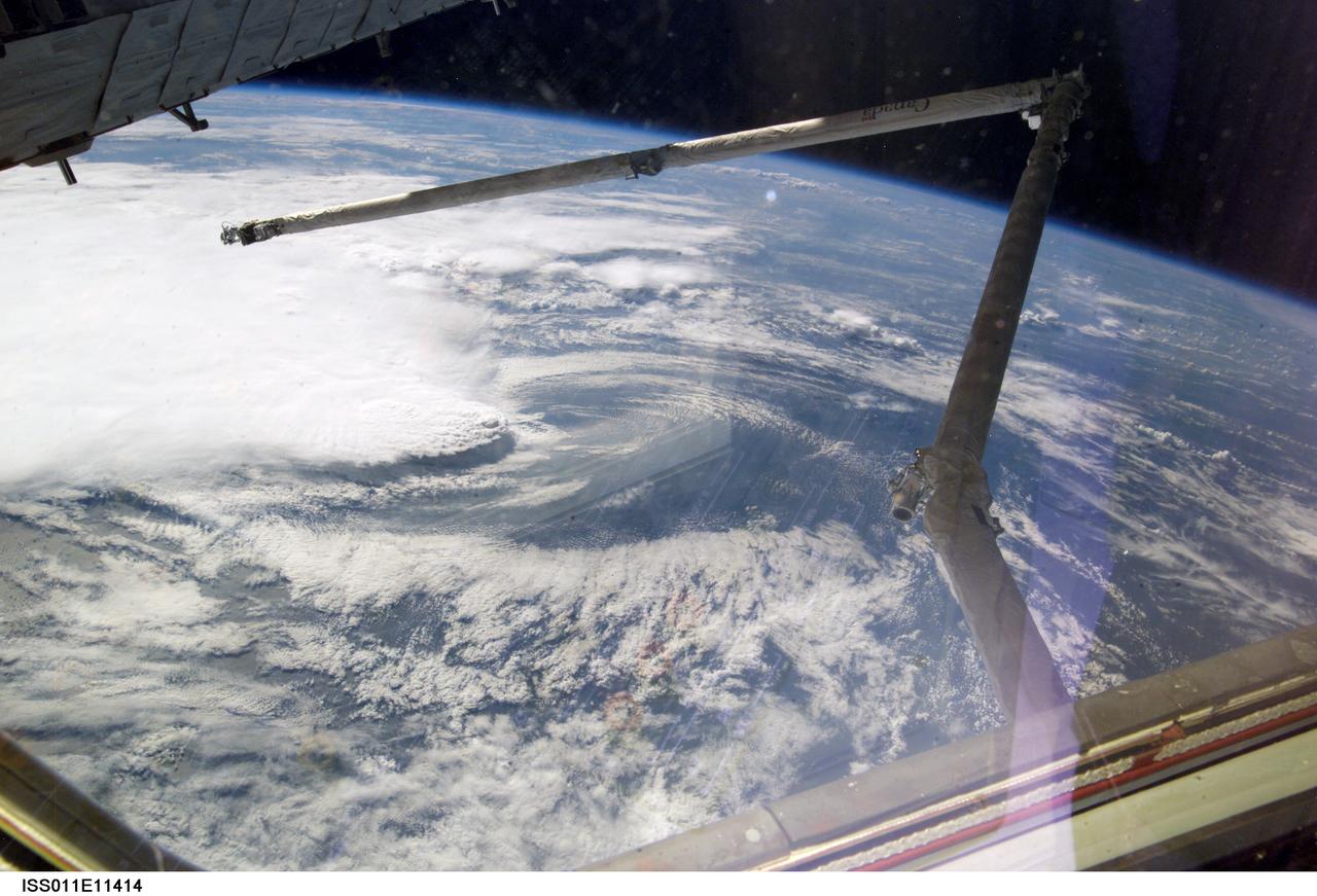 ISS011-E-11414 (2 August 2005) --- A line of thunderstorms form the backdrop for this view of the extended Space Shuttle Discovery’s remote manipulator system (RMS) robotic arm while docked to the International Space Station during the STS-114 mission.