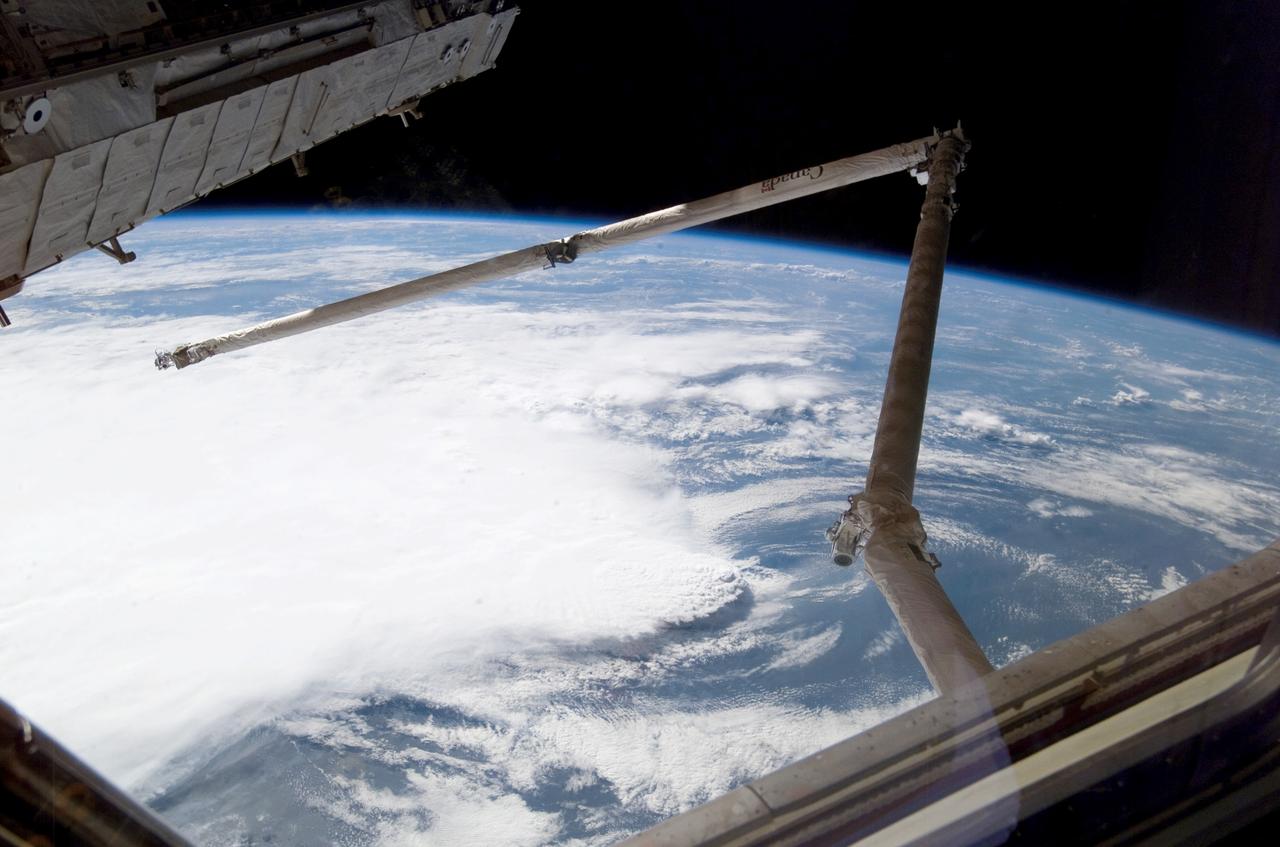 ISS011-E-11416 (2 August 2005) --- A line of thunderstorms form the backdrop for this view of the extended Space Shuttle Discovery;s remote manipulator system (RMS) robotic arm while docked to the International Space Station during the STS-114 mission.