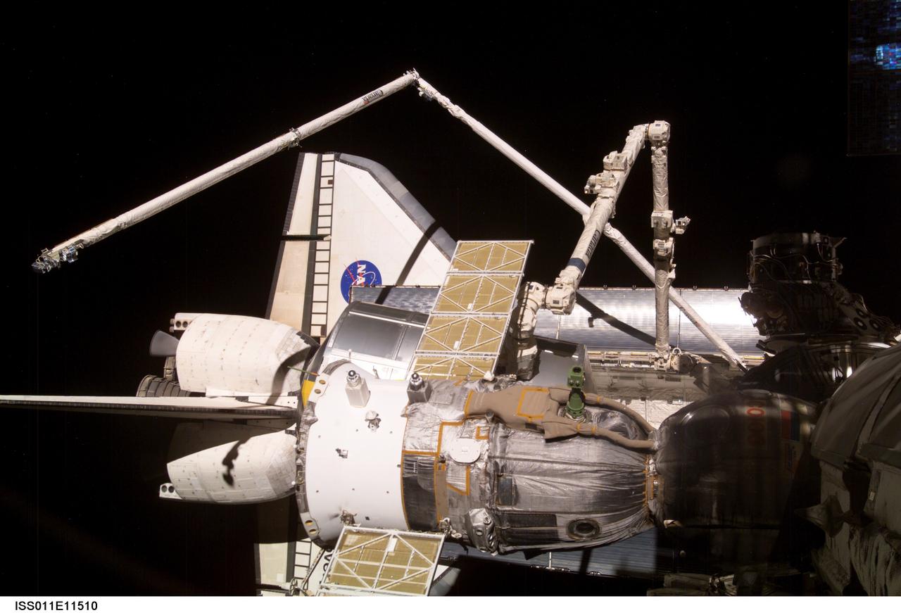 ISS011-E-11510 (5 August 2005) --- On the eve of the separation of  Discovery and the International Space Station, an Expedition 11 crew member took this digital still picture.  Crews onboard the orbital outpost and Discovery were wrapping up nine days of joint operations. The Space Shuttle is partially visible beneath other hardware.  The Canadian-built robot arms for both spacecraft are dominant in the frame. A Russian Soyuz is docked to the Station in the foreground.   After the Italian-built Multi-Purpose Logistics Module Raffaello was secured in Discovery's cargo bay, Astronauts Charles J. Camarda and Andrew S.W. Thomas, mission specialists operating from Discovery's aft flight deck, used the Shuttle arm to hand off the Orbiter Boom Sensor System to the Station arm. Then Astronauts Wendy B. Lawrence, mission specialist, and James M. Kelly, pilot, onboard Destiny, reberthed the OBSS in its position on the starboard sill of the cargo bay. Undocking is scheduled shortly before 2:30 a.m. (CDT) on August 6.