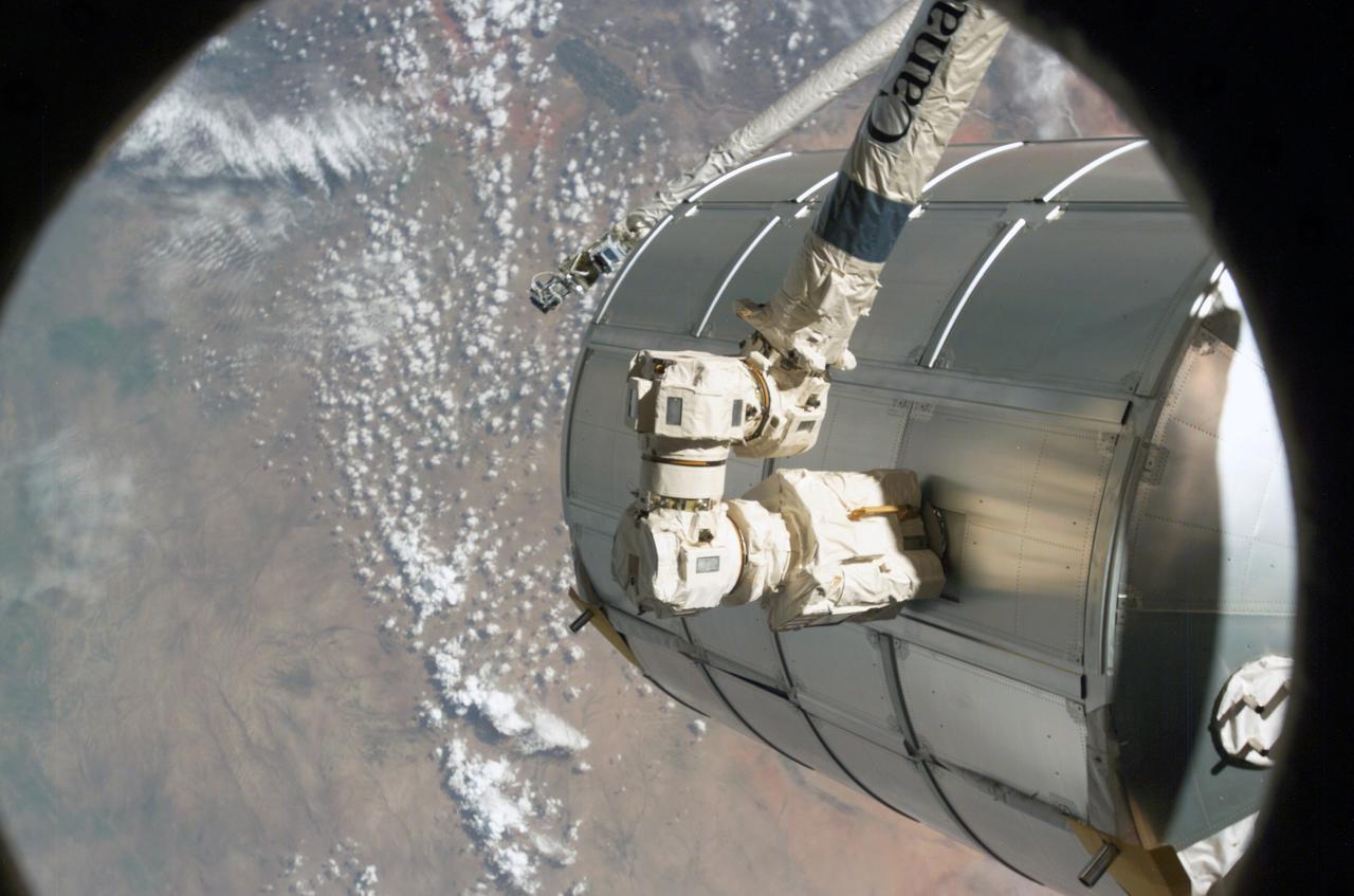 ISS011-E-11517 (5 August 2005) --- Canadarm2 or the Space Station Remote Manipulator System arm grasps the Italian-built Multi-Purpose Logistics Module Raffaello to place it back in Discovery's cargo bay. On the other end of the arm, inside the shirt sleeve environment of the U.S. Lab, Destiny, on the international space station, Astronauts James M. Kelly, pilot, and Wendy B. Lawrence, mission specialist, were in control of the transfer. The MPLM was being moved from its temporary parking place on the Station's Unity node to the payload bay of Discovery for the return trip to Earth. The Discovery astronauts arrived nine days ago with tons of fresh supplies for the Station, and with much effort, replaced that space on Raffaello with unneeded materials from the orbital outpost.