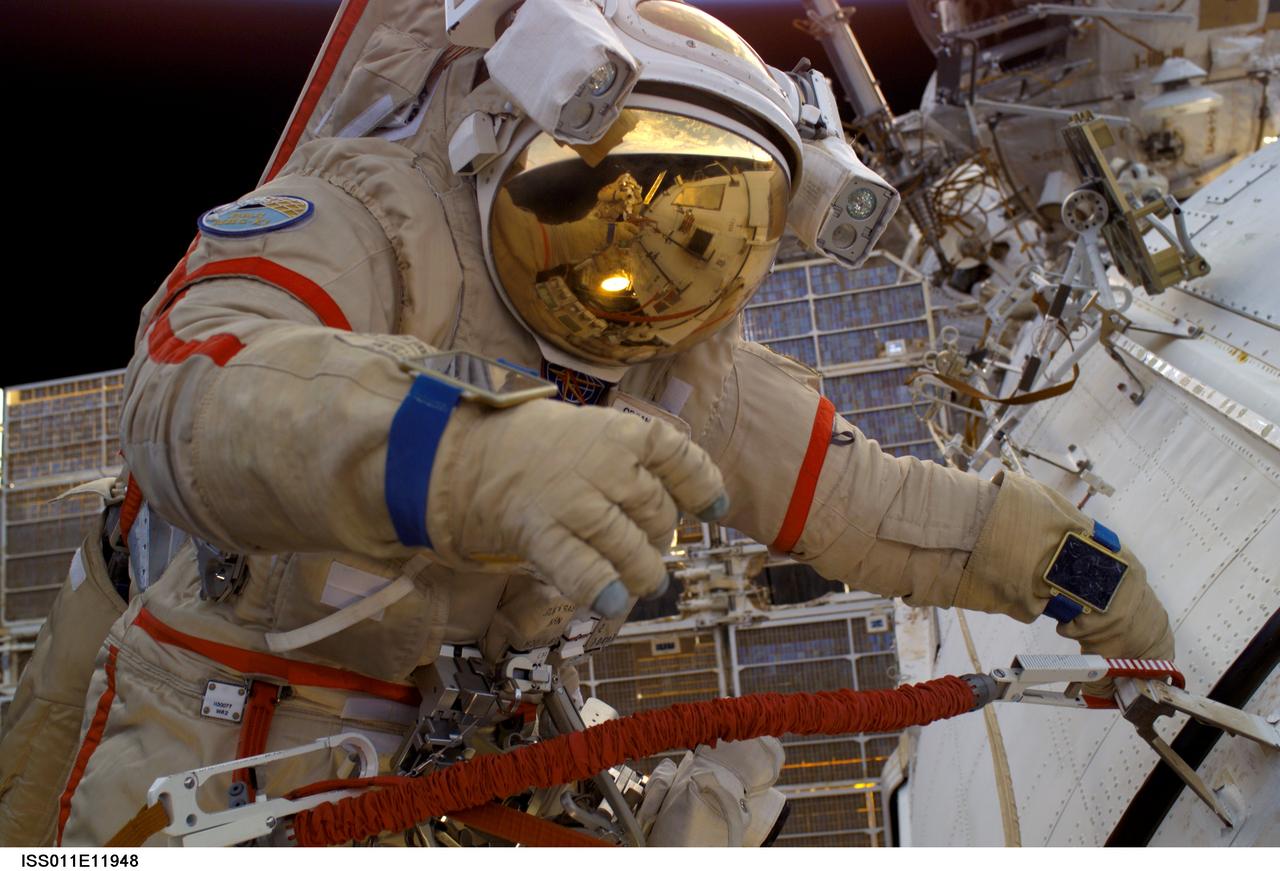 ISS011-E-11948 (18 August 2005) --- Attired in a Russian Orlan spacesuit, astronaut John L. Phillips, Expedition 11 NASA Space Station science officer and flight engineer, participates in a session of extravehicular activity (EVA). The 4 hour 58 minute spacewalk by Phillips and cosmonaut Sergei K. Krikalev (seen in Phillip;s helmet visor), commander representing Russia's Federal Space Agency, was the 62nd EVA in support of Station assembly and maintenance, the 34th conducted from the Station itself, and the 16th from the Pirs Docking Compartment.
