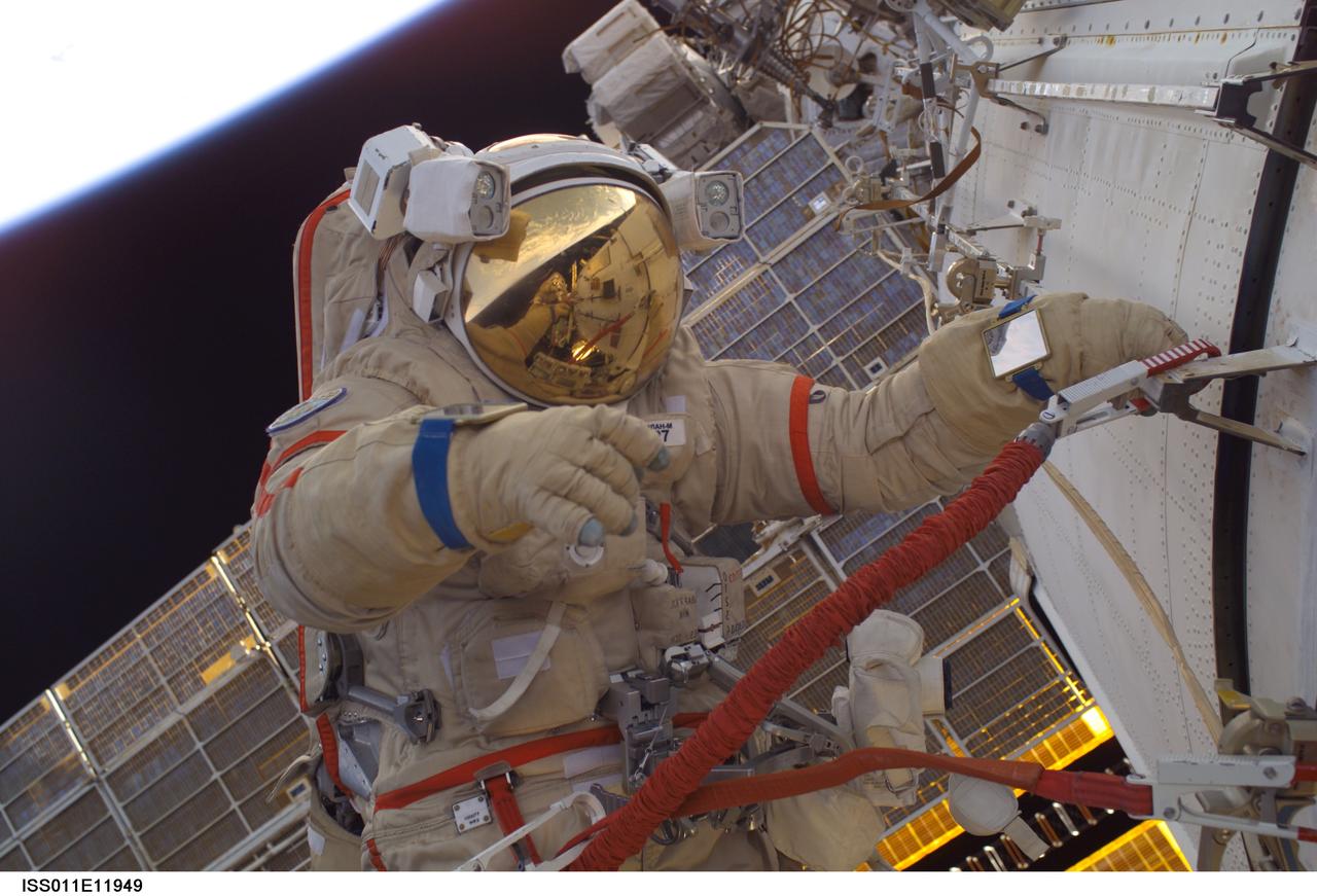 ISS011-E-11949 (18 August 2005) --- Attired in a Russian Orlan spacesuit, astronaut John L. Phillips, Expedition 11 NASA Space Station science officer and flight engineer, participates in a session of extravehicular activity (EVA). The 4 hour 58 minute spacewalk by Phillips and cosmonaut Sergei K. Krikalev (seen in Phillip;s helmet visor), commander representing Russia's Federal Space Agency, was the 62nd EVA in support of Station assembly and maintenance, the 34th conducted from the Station itself, and the 16th from the Pirs Docking Compartment.