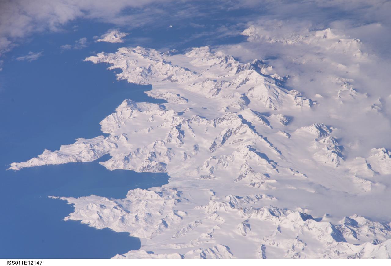 ISS011-E-12147 (26 Aug. 2005) --- South Georgia Island is featured in this image photographed by an Expedition 11 crewmember on the International Space Station. There is no permanent human base on South Georgia Island, a British territory in the South Atlantic Ocean that lies 1300 kilometers east of the Falkland Islands. Using a long lens (800 mm focal length) and positioned for an oblique view, the crew of the international space station was able to capture the rugged and isolated landscape of the northern shore of the island. The high mountains protect the north and eastern coast of the island from the prevailing gales coming from Antarctica and the west. The steep topography also makes deep embayments along the coast that provide habitat for wildlife and anchorages for whaling ships. The island supports major rookeries of penguins and albatrosses, and large seal populations. This view centers on Mt. Paget and Cumberland Bay. The former whaling station Grytviken is located within the bay. The encampment supports the scientific base for the British Antarctic Survey and Bird Island Research Station.