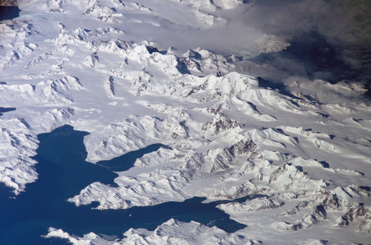 ISS011-E-12148 (26 August 2005) --- South Georgia Island is featured in this image photographed by an Expedition 11 crewmember on the international space station. There is no permanent human base on South Georgia Island, a British territory in the South Atlantic Ocean that lies 1300 kilometers east of the Falkland Islands. Using a long lens (800 mm focal length) and positioned for an oblique view, the crew of the international space station was able to capture the rugged and isolated landscape of the northern shore of the island. The high mountains protect the north and eastern coast of the island from the prevailing gales coming from Antarctica and the west. The steep topography also makes deep embayments along the coast that provide habitat for wildlife and anchorages for whaling ships. The island supports major rookeries of penguins and albatrosses, and large seal populations. This view centers on Mt. Paget and Cumberland Bay. The former whaling station Grytviken is located within the bay. The encampment supports the scientific base for the British Antarctic Survey and Bird Island Research Station.