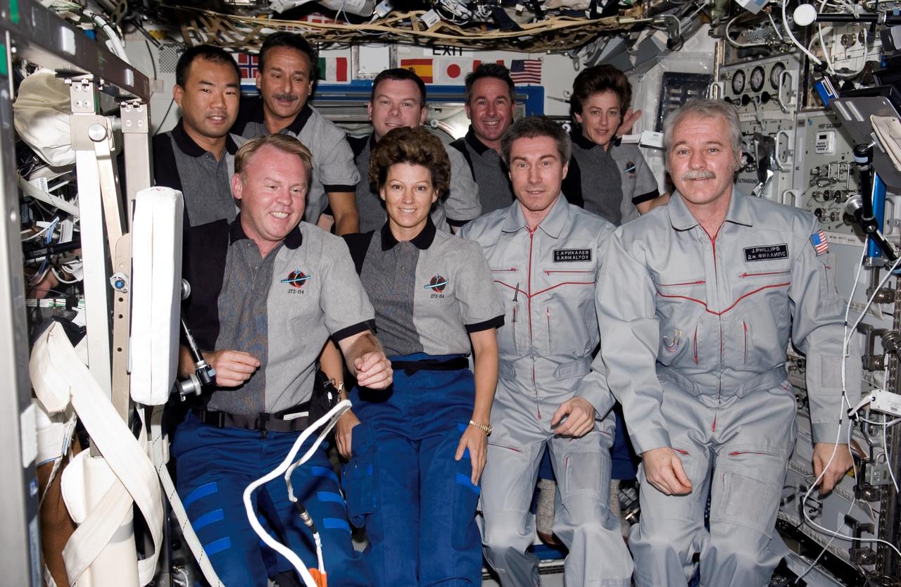 ISS011-E-12407 (2 August 2005) --- The STS-114 and Expedition 11 crew members gather for a group photo in the Destiny laboratory of the international space station. From the left (front row) are astronauts Andrew S. W. Thomas, STS-114 mission specialist; Eileen M. Collins, STS-114 commander; cosmonaut Sergei K. Krikalev, Expedition 11 commander representing Russia's Federal Space Agency; and astronaut John L. Phillips, Expedition 11 NASA science officer and flight engineer. From the left (back row) are astronauts Soichi Noguchi representing Japan Aerospace Exploration Agency (JAXA) and Charles J. Camarda, both STS-114 mission specialists; James M. Kelly, STS-114 pilot; Stephen K. Robinson and Wendy B. Lawrence, both STS-114 mission specialists.