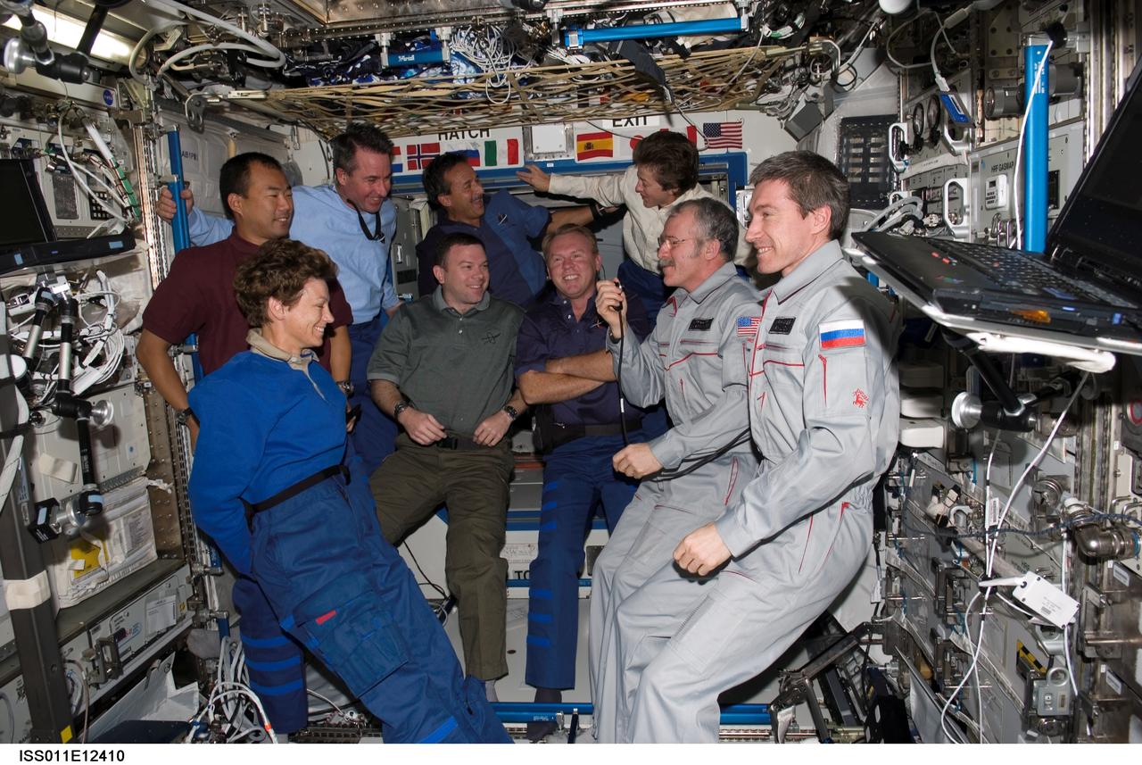 ISS011-E-12410 (6 August 2005) --- The STS-114 and Expedition 11 crewmembers gather in the Destiny laboratory of the International Space Station. From the left (front row) are astronaut Eileen M. Collins, STS-114 commander; James M. Kelly, STS-114 pilot; Andrew S. W. Thomas, STS-114 mission specialist; John L. Phillips, Expedition 11 NASA Space Station science officer and flight engineer; and cosmonaut Sergei K. Krikalev, Expedition 11 commander representing Russia's Federal Space Agency. From the left (back row) are astronauts Soichi Noguchi representing Japan Aerospace Exploration Agency (JAXA), Stephen K. Robinson, Charles J. Camarda, and Wendy B. Lawrence, all STS-114 mission specialists.