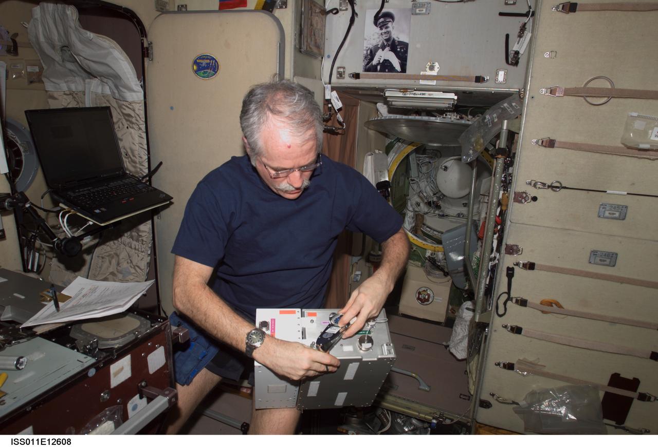 ISS011-E-12608 (7 September 2005) --- Astronaut John L. Phillips, Expedition 11 NASA Space Station science officer and flight engineer, works with a portion of the Treadmill Vibration Isolation System (TVIS) during In-Flight Maintenance (IFM) in the Zvezda Service Module of the International Space Station.