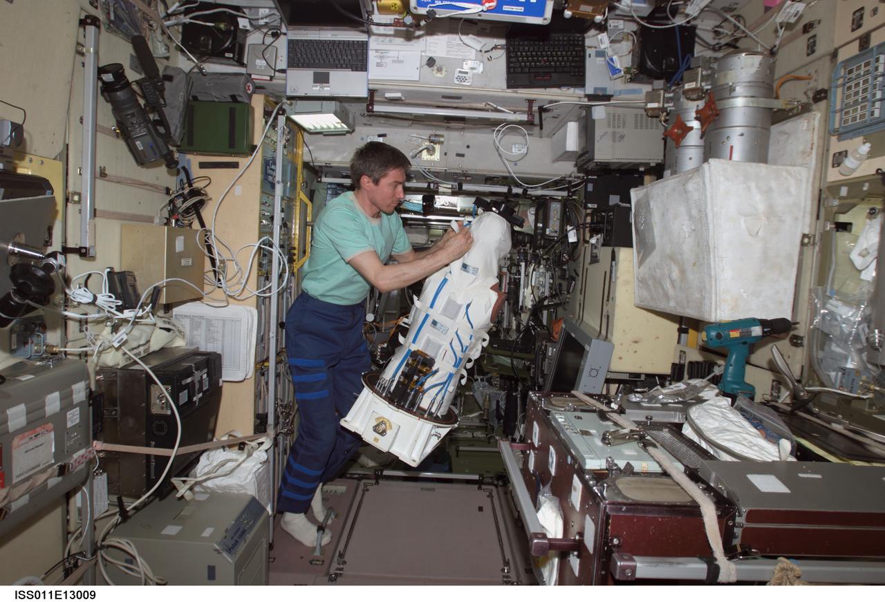 ISS011-E-13009 (14 September 2005) --- Cosmonaut Sergei K. Krikalev, Expedition 11 commander representing Russia's Federal Space Agency, works with the European Space Agency (ESA) Matroshka radiation experiment in the Zvezda Service Module of the International Space Station. Matroshka, a human-torso-like device, was retrieved from the exterior of the station during an August spacewalk, for return to Earth. The experiment is designed to better understand the exposure of astronauts, including those making spacewalks, to radiation.