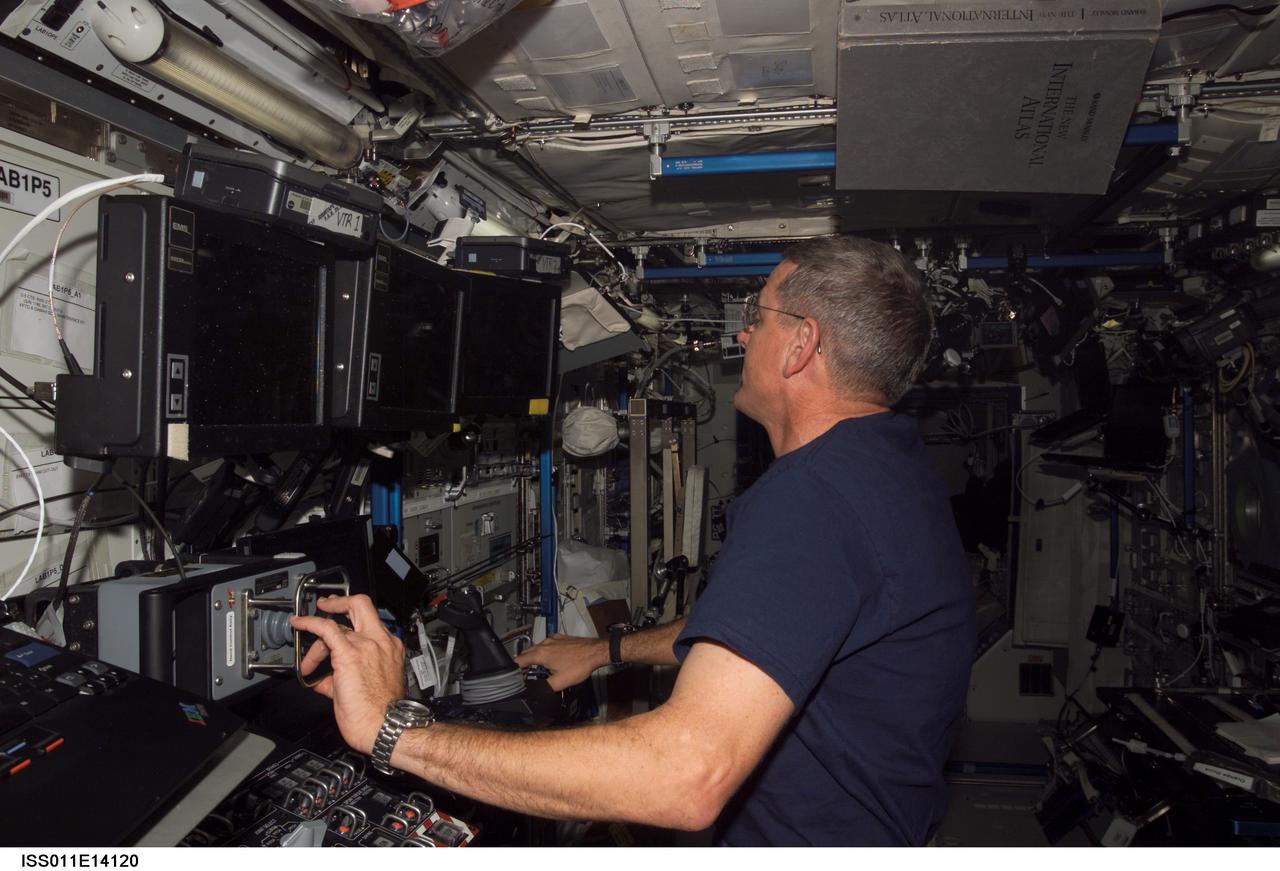 ISS011-E-14120 (5 October 2005) --- Astronaut William S. McArthur, Jr., Expedition 12 commander and NASA science officer, works with Space Station Remote Manipulator System or Canadarm2 controls located in the Destiny lab, while sharing duty time with the Expedition 11 crewmembers on the international space station. The Expedition 11 crew of cosmonaut Sergei K. Krikalev of Russia's Federal Space Agency, commander, and astronaut John L. Phillips, flight engineer and NASA science officer, along with spaceflight participant Greg Olsen, will be returning to Earth early next week.