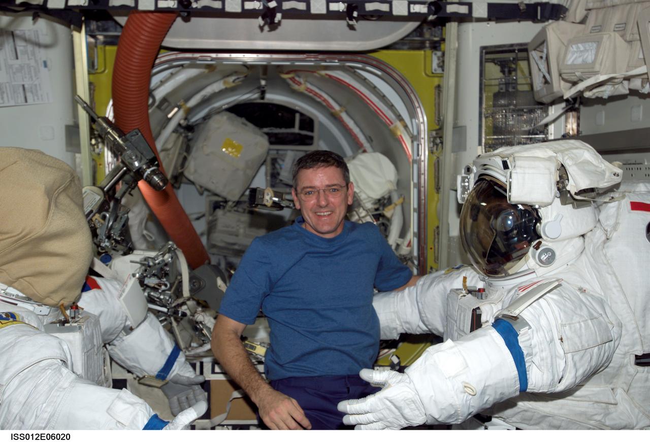 ISS012-E-06020 (26 October 2005) --- Astronaut William S. McArthur Jr., Expedition 12 commander and NASA science officer, works with Extravehicular Mobility Unit (EMU) spacesuits in the Quest airlock of the international space station. When the Expedition 12 crew performs its first scheduled day of spacewalking on Nov. 7, it will be attired in the NASA EMU.
