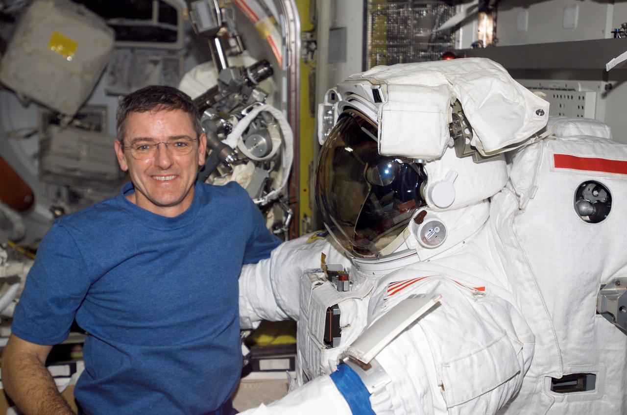 ISS012-E-06022 (26 Oct. 2005) --- Astronaut William S. McArthur Jr., Expedition 12 commander and NASA science officer, works with Extravehicular Mobility Unit (EMU) spacesuits in the Quest airlock of the international space station. When the Expedition 12 crew performs its first scheduled day of spacewalking on Nov. 7, it will be attired in the NASA EMU.