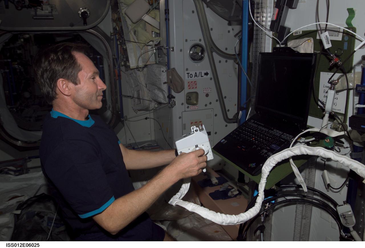 ISS012-E-06025 (21 October 2005) --- Cosmonaut Valery I. Tokarev, Expedition 12 flight engineer representing Russia's Federal Space Agency, holds a Hand Control Module (HCM) while looking at laptop computer graphics during a Simplified Aid for EVA Rescue (SAFER) training session in the Unity node of the international space station.