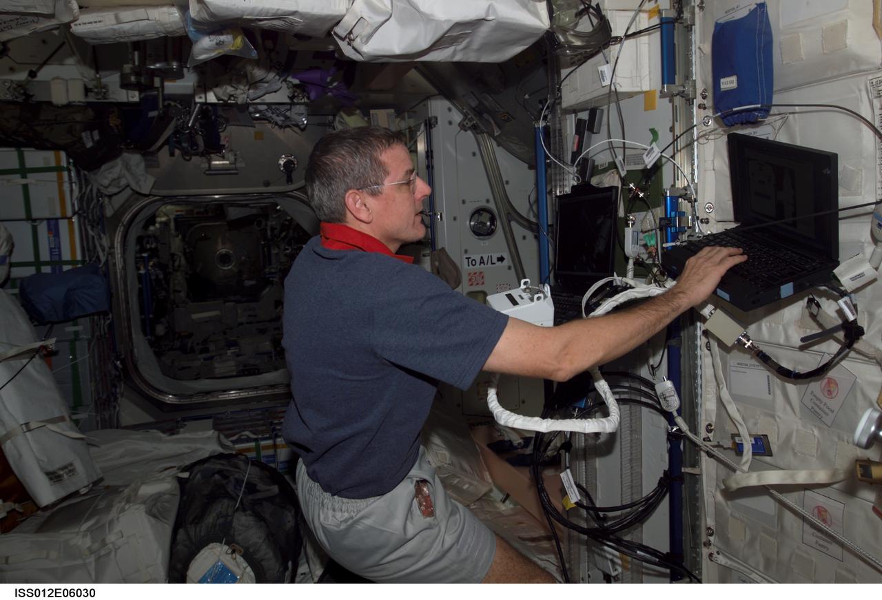 ISS012-E-06030 (21 October 2005) --- Astronaut William S. McArthur Jr., Expedition 12 commander and NASA science officer, holds a Hand Control Module (HCM) while looking at laptop computer graphics during a Simplified Aid for EVA Rescue (SAFER) training session in the Unity node of the international space station.