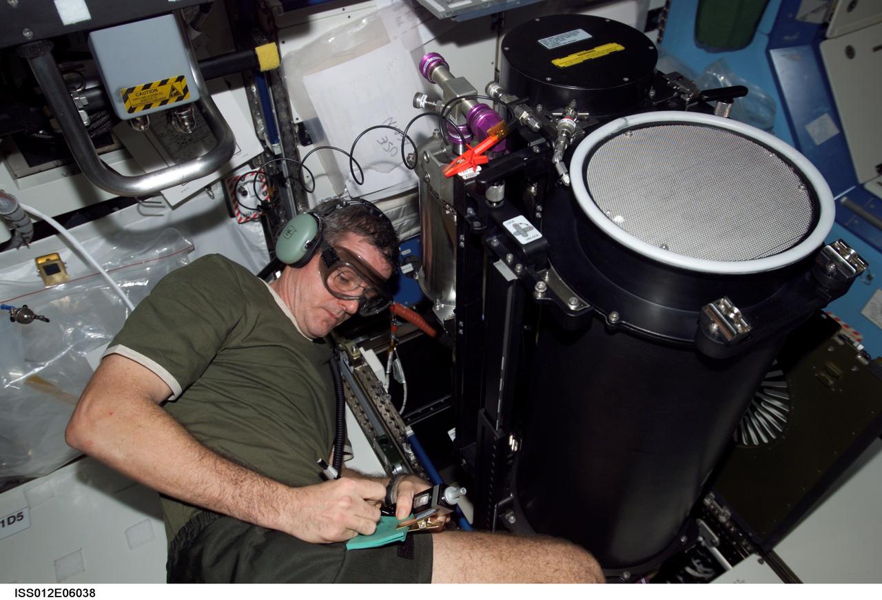 ISS012-E-06038 (31 October 2005) --- Astronaut William S. McArthur Jr., Expedition 12 commander and NASA science officer, conducts troubleshooting operations on the Trace Contaminant Control Subassembly (TCCS) in the Destiny laboratory of the international space station.