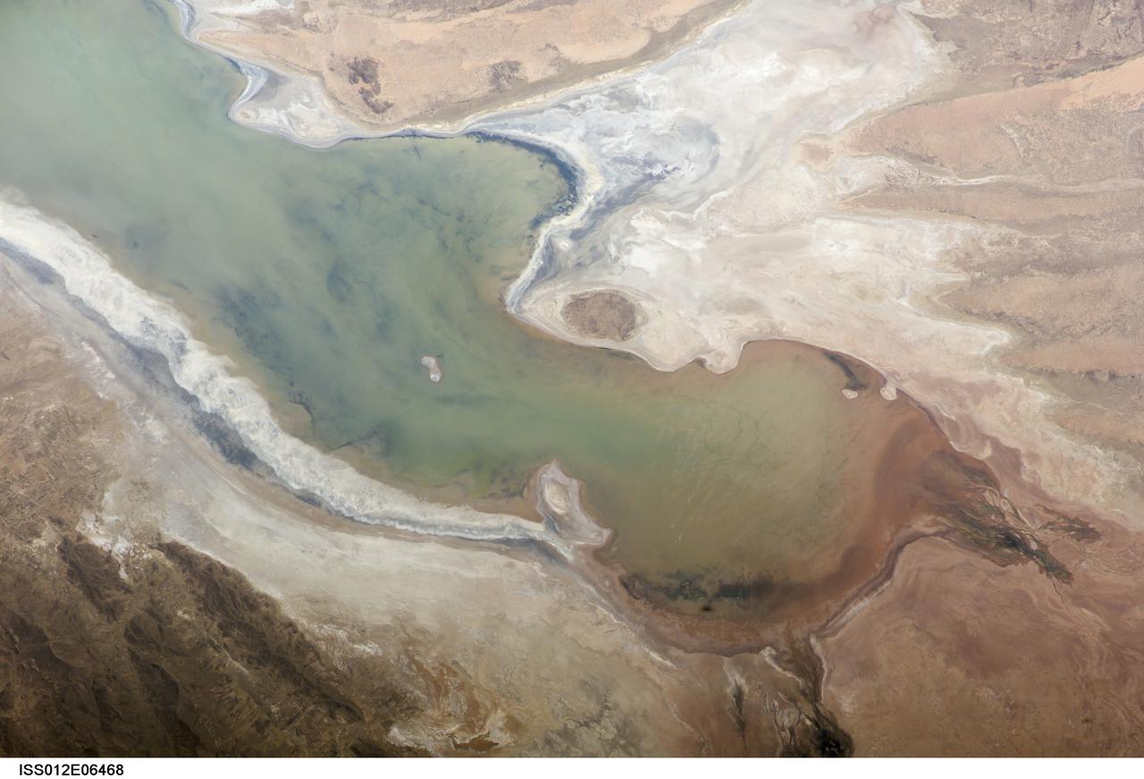 ISS012-E-06468 (3 Nov. 2005) --- A portion of Lake Poopo is featured in this image photographed by an Expedition 12 crewmember on the International Space Station. Lake Poopo sits high in the Bolivian Andes, catching runoff from its larger neighbor to the north - Lake Titicaca (not shown) - by way of the Desaguadero River (muddy area at the north end of the lake). Because Lake Poopo is very high in elevation (roughly 3400 meters or 11,000 feet above sea level), very shallow (generally less than 3 meters or 9 feet), and the regional climate is very dry, small changes in precipitation in the surrounding basin have large impacts on the water levels and areal extent of Lake Poopo. When the lake fills during wet periods, Poopo drains from the south end into Salar de Coipasa (not shown). Water levels in Poopo are important because it is one of South America&#0146;s largest saline lakes, and a prime stop for migratory birds, including flamingoes. NASA managers have tasked the station crew to track such changes, which are related to regional weather patterns. Lake Poopo&#0146;s sensitivity to precipitation in the high Andes (possibly reflecting larger climate cycles) provides an excellent visual indicator of these trends.