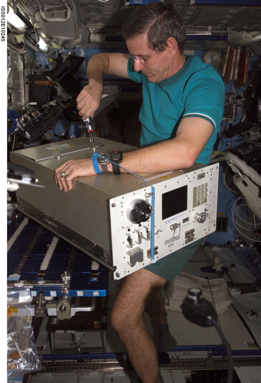 ISS012-E-10245 (5 December 2005) --- Astronaut William S. (Bill) McArthur Jr., Expedition 12 commander and NASA space station science officer, performs in-flight maintenance (IFM) on the Volatile Organic Analyzer (VOA) in the Destiny laboratory of the International Space Station.